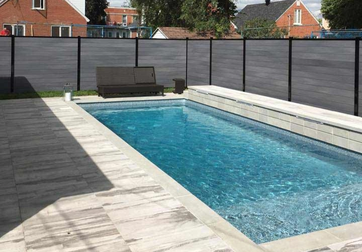 Clôture en composite grise autour d'une piscine creusée
