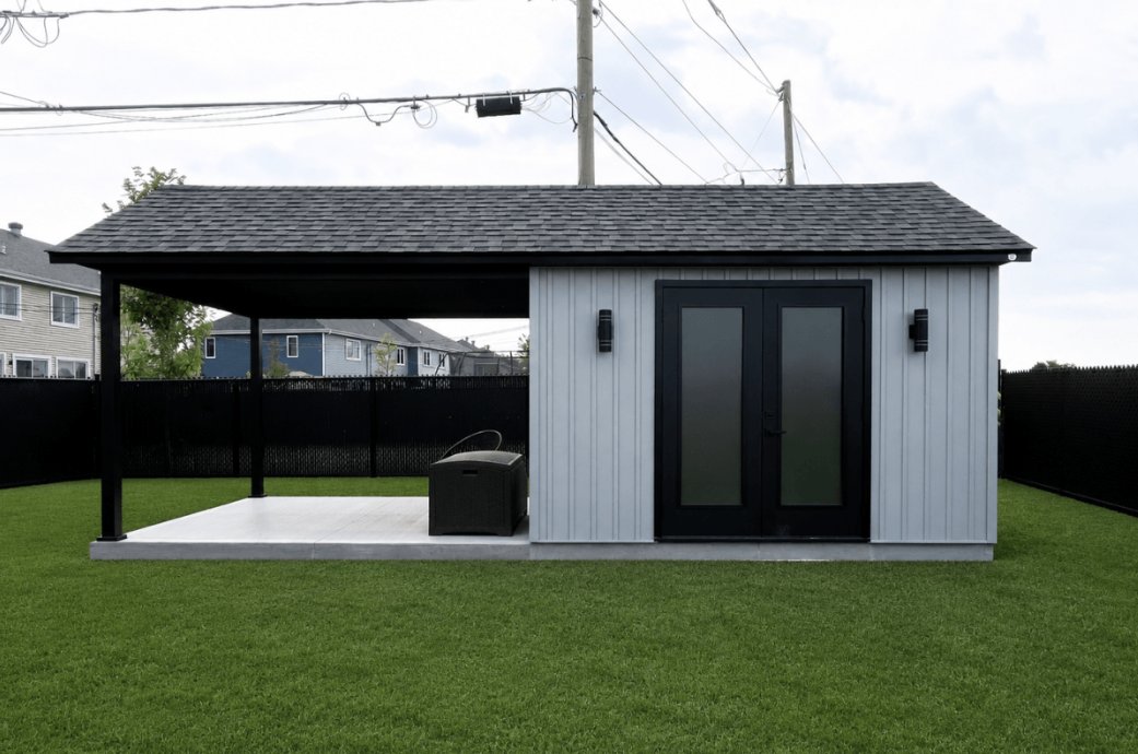 Cabanon noir avec terrasse couverte et coin salon extérieur